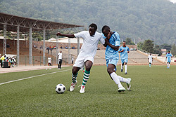 Kiyovuu2019s Julius Bakkabulindi (L) holds off Isongau2019s defender during last weeku2019s Primus League encounter at Kigali Regional Stadium. The striker will lead Kiyovuu2019s attack against Simba. The New Times / T. Kisambira