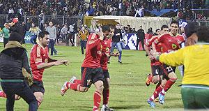 Al-Ahly players ran for their lives as rival fans streamed onto the pitch and headed towards them, throwing bottles and fireworks. Net photo.