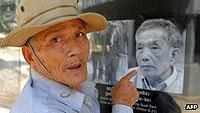 A survivor of the infamous Tuol Sleng prison points to a picture of Khmer Rouge jailer Comrade Duch. Net photo.