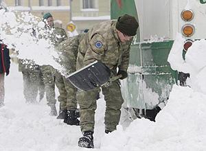 Turkish soldiers, members of the European Union Force in Bosnia-Herzegovina, shovel snow from tracks beneath a frozen tram Sunday in the Bosnian capital of Sarajevo.
