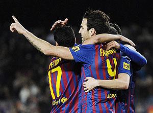 Cesc Fabregas (R) celebrates with teammates after scoring Barcelona's opener against Valencia. Net photo