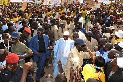 Senegalu2019s President Abdoulaye Wade (C) walks among his supporters as he arrives for a rally in the capital of the Casamance region Ziguinchor. Net photo.