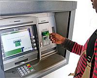 A client uses a KCB teller machine in Kigali. Banks will benefit from a continental approach towards curbing cyber crime. The New Times / File.