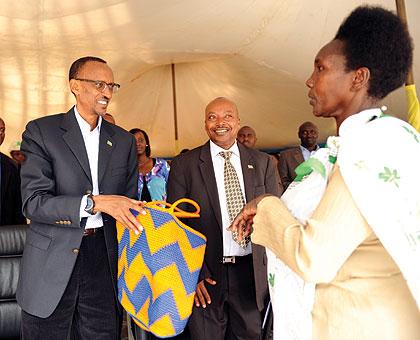 President Kagame receives a gift from Margarita Nyirabanyaga, a local artisan from Ngororero who has successfully built a handbags business.  The New Times / Village Urugwiro.