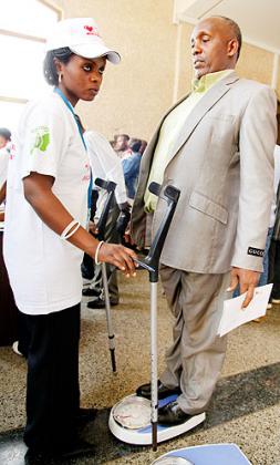 MP Pierre Claver Rwaka stands on a weighing scale during the diabetes heart campaign at Parliamentary buildings. The New Times / File.