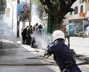  A police officer fires tear gas at close range directly into a group of anti-government protesters sheltering behind a kiosk, on a central boulevard in Dakar, Senegal, Saturday. Net photo.