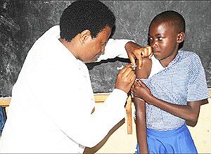 A school girl takes a cervical cancer vaccine last year. The country projects to have elimanated this cancer over the next 40 years. The New Times / File