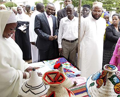 One of the exhibitors happily shows off her products to Mufti Sheikh Abdul Karim Gahutu (in spects) and MP Sau00efdat Mukanoheli (R). The New Times / Timothy Kisambira