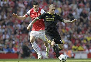 Liverpool defender Srktel holds off Arsenal star striker Robin van Persie. The two will be at it again this afternoon.  Net photo.
