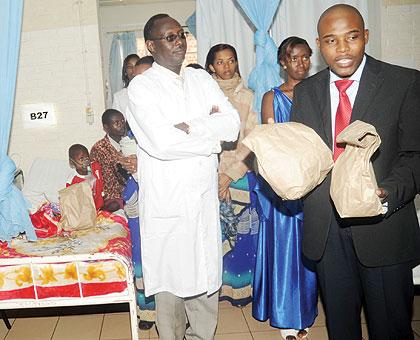 CHUK Director Dr Theobald Hategekimana (L) with Paster Ezekiel Motsoeneng distributing gifts to patients in the hospital wards yesterday. The New Times / John Mbanda.