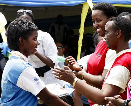 The First Lady, Mrs Jeannette Kagame (L), and the Minister of Gender and Family Promotion, Aloysia Inyumba award one of the best performing students, yesterday. The New Times / T. Kisambira.