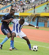 Rayonu2019s Sina Jerome shields the ball from Police defender Aboubaker Nshimiyimana in a first leg encounter at Amahoro stadium (The New Times, T. Kisambira)