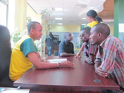 u2018Simbuka na Bank Populaireu2019 employee explains to the clients the advantages of using mobile banking. The New Times/L. Mbabazi.  