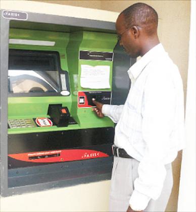 A man withdraws money from an ATM. A survey conducted last year, indicates that banks in the region lost millions in cyber fraud.  The New Times / File