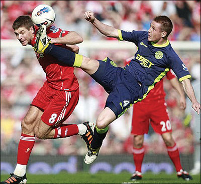 Liverpool's Steven Gerrard (left) vies for the ball against Wigan Athletic's James McCarthy. Net photo.