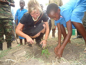 Sophie Charlotte of Rhineland Palatine Province helps a school girl plant a tree at Mutima School in Ruhango District. 
