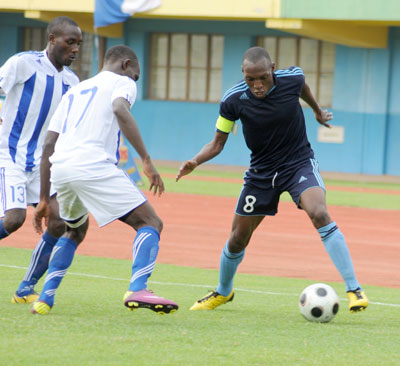 Police captain Meddie Kagere (R) dribbles past Rayon Sport defenders during a past league match. Police are on track to win their first league title. The New Times/File.