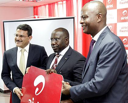 L-R: Manoj Kohli, CEO, Bharti Airtel; Premier Dr Habumuremyi; and Airtel Country Manager, Marcellin Paluku, pose with a dummy Airtel Sim card yesterday. The New Times / Timothy Kisambira.