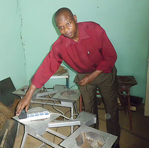 Aimable Mugabo demostrates how cost effective eco-friendly stoves work. The New Times / G. Mugoya.