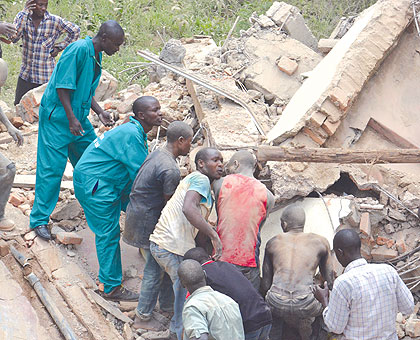 Builders and other people try to rescue workers who were trapped under the rubble when a building in Kigali collapsed on them yesterday.The New Times / Najib Nsubuga.