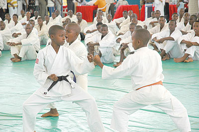 The old guards look on in awe as some of Rwandau2019s future Karate champions sweat it out in a past Kumite (sparring) session.  The New Times/File.