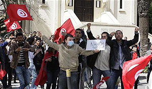 Demonstrators wave flags and shout slogans during a protest in Tunis April 9, 2012. Net photo.