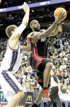 Miami Heatu2019s LeBron James, right, drives against New Jersey Netsu2019 Brook Lopez during the game against the New Jersey Nets. Net photo.