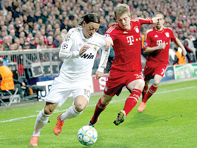 The Real Madridu2019s Mesut Ozil (L) is under pressure from his Germany international team-mate Toni Kroos in the first leg in Germany. Net photo.