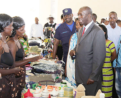 Exhibitors explain to the Minister of Public Service and Labour, Anastase Murekezi (R), at the Labour Day Expo, yesterday.The New Times / Timothy Kisambira.