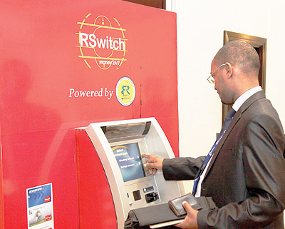 A bank customer withdraws money using his ATM card at Serena Hotel during a past workshop at the facility. The New Times / Timothy Kisambira.