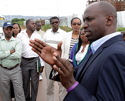 Alex Ruzibuka (R), Director General for Entrepreneurship at the Ministry of Trade and Industry, addressing MPs who were touring Kigali City suburbs and the Rwanda Special Economic Zone (RSEZ) yesterday. The New Times / T. Kisambira. 