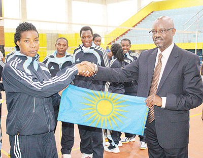 RRA Captain Regina Izabayo recieves the national flag from Rwanda Revenue Authority Commissoner General Ben Kagarama. The New Times/Courtesy.