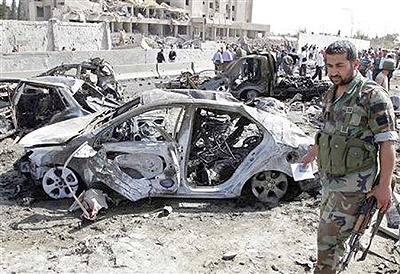 Residents and security personnel gather at the site of an explosion in Damascus May 10, 2012. Two large explosions killed 40 people in Damascus on Thursday, state media said, destroying dozens of cars on a highway and damaging an intelligence complex invo
