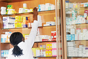 A Pharmacist selecting drugs from the shelf. A call has been made to institute a drugs' regulatory body. The New Times / File