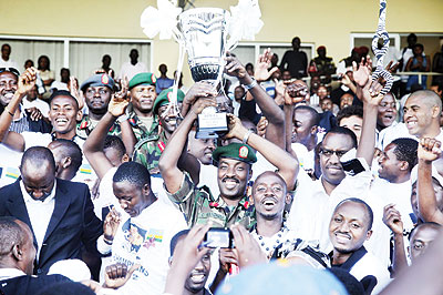 CROWNED: RDF's Chief of Defence Staff, Lit. Gen. Charles Kayonga lifts aloft the Primus League trophy, sorrounded by APR players and officials at Stade de Kigali yesterday. The New Times / T. Kisambira.