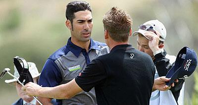 Alvaro Quiros (L) is congratulated by Ian Poulter (R) after his victory over the Englishman. Net photo.