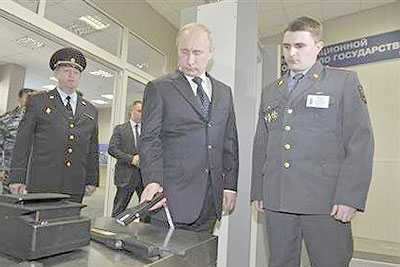 Russian President Vladimir Putin (C) uses a security device during a visit to the Interior Ministry Academy in Moscow. Net photo