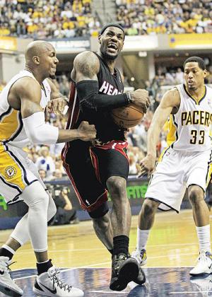 LeBron James (C) of the Miami Heat drives between David West (L) and Danny Granger (R) of the Indiana Pacers on his way to a game-high 40 points. Net photo.