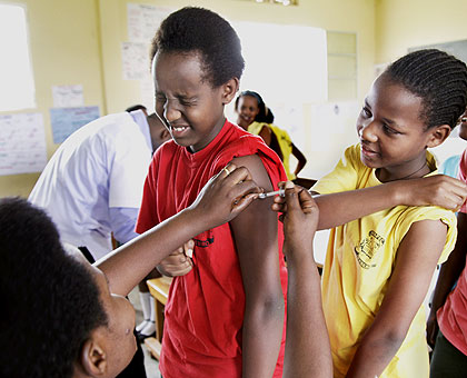 Seraphine Mukanyarwaya (L), Nurse at Kagugu Health Centre Immunizing pupils of APAPEC IREBERO Primary School.The New Times/Timothy Kisambira.