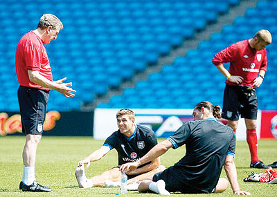 England manager has a word with Gerrard and Carroll in his first training session on Thursday ahead of Saturday's friendly with Norway. Net photo.