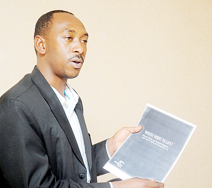 Cassien Havugimana of HDI showing a document to journalists during the press briefing. The New Times/John Mbanda.