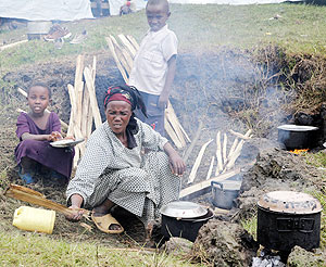 A refugee prepares a meal at Nkamira refugee transit camp. The New Times / File.