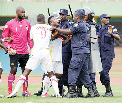 UGLY SCENES: Benin's captain Stu00e9phane Sessegnon (C), striker Abou Maiga (9) and keeper Farnolle engage in ugly shoving with police officers at full time. The New Times/T. Kisambira.