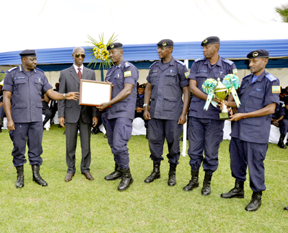 IGP Gasana hands a certificate for the unit of the year to Central Region Police Commander CSP Rogers Rutikanga while District Police Commanders admire the trophy. The New Times / Courtesy.