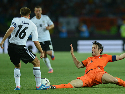 The Netherlands' captain Mark van Bommel goes in for a challenge against his Germany counterpart Phillip Lahm in the previous match. Net photo