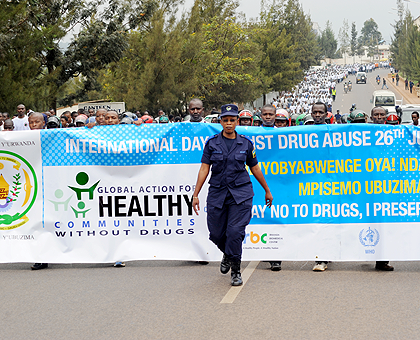 A police officer leads the youth during a march through the streets of Kigali yesterday to mark the World Drugs Day.The New Times / John Mbanda. 