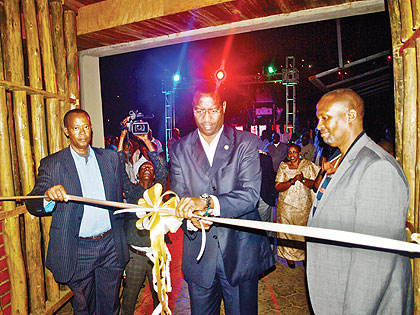 The Minister of Culture and Sports, Protais Mitali cuts the ribbon to Mysterious club. Looking on (R) is Cobra. 