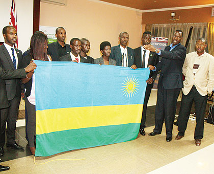Minister of Sports and Culture Protais Mitali (2nd right) hands over the national flag to the departing team yesterday. The New Times/Courtesy.