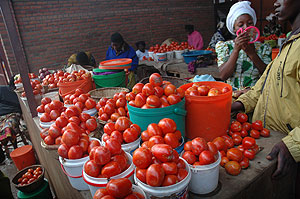 A woman selling tomatoes. Tomato and banana prices are set to decline. The New Times / File.