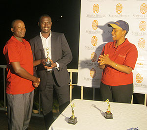 Cu00e9lestin Habineza receives the winning trophy from Kigali Golf Club President Dr.R.Gakuba as Serenau2019s Denise Omany looks on. The New Times/A. Olwit.